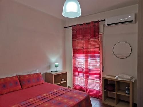 a bedroom with a bed and a red curtain at ZAHRA ARAGONA in Aragona