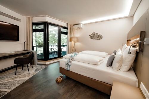 a hotel room with a bed and a desk at Seehotel am Tankumsee in Isenbüttel