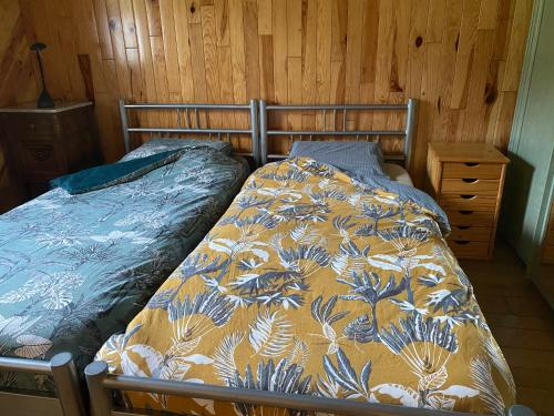 a bedroom with a bed and a wooden wall at L'évasion du berger australien in Couvin