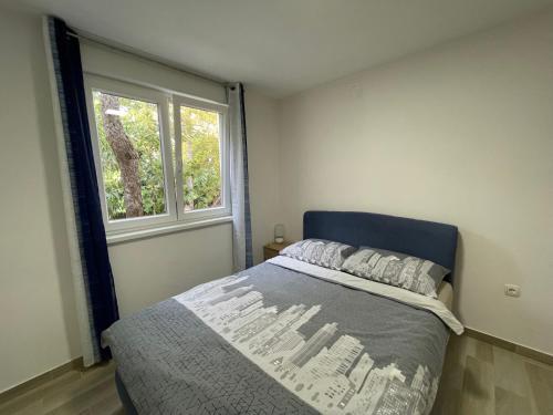 sypialnia z łóżkiem i oknem w obiekcie Apartment Oliveglia w mieście Šilo