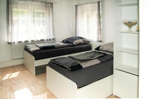- 2 lits dans une chambre avec 2 fenêtres dans l'établissement Ferienwohnung Jagsthausen, à Jagsthausen