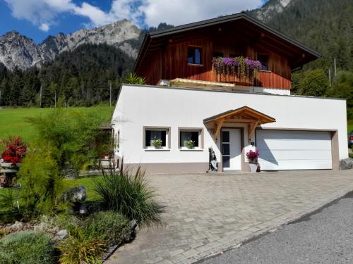 a white building with a balcony on top at Haus Adrian in Wald am Arlberg