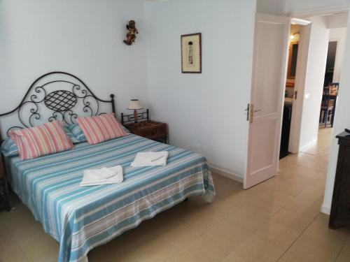 a bedroom with a bed with a blue and striped blanket at Respira el mar desde tu terraza y siéntete en paz. in Arrieta