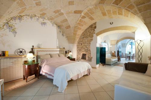 a bedroom with a bed and a stone wall at Casa d'Artista Suite & Garden in Lecce