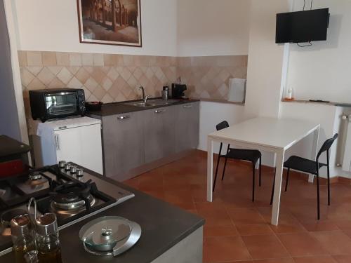 a small kitchen with a table and a stove at La casa in giardino in Volterra