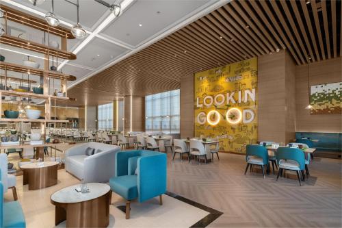 a dining room with tables and chairs and a restaurant at Holiday Inn Fuyang by IHG in Fuyang