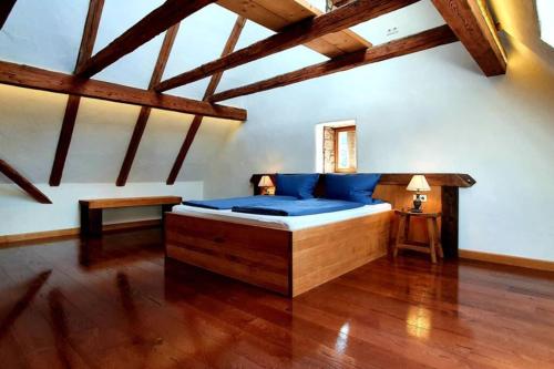 1 dormitorio con 1 cama en una habitación con suelo de madera en Apartment Vertex, en Creglingen