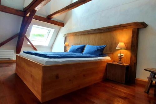 a bedroom with a large wooden bed with blue pillows at Apartment Vertex in Creglingen