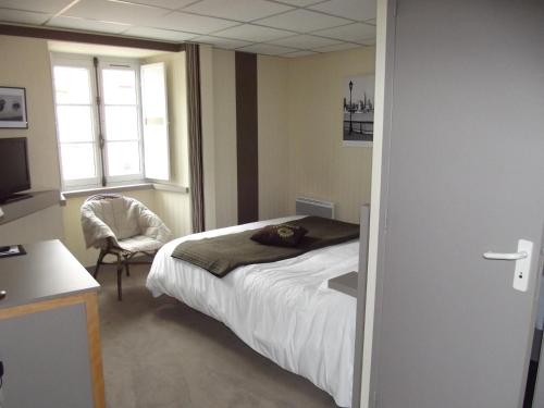 a bedroom with a bed and a chair and a window at Le Minotel in Vitré