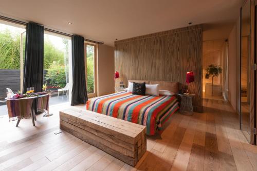 ein Schlafzimmer mit einem Bett und einer Bank in einem Zimmer in der Unterkunft Hotel Bo in San Cristóbal de las Casas