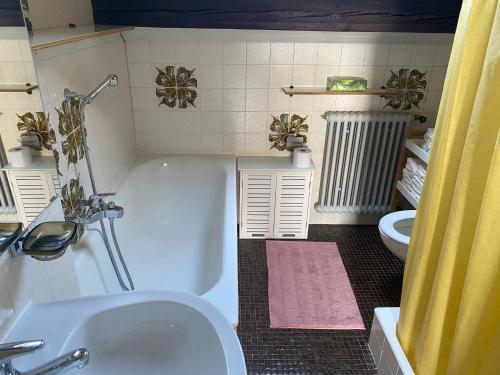 La salle de bains est pourvue d'une baignoire, de toilettes et d'un lavabo. dans l'établissement Beauregard attique, à Lausanne