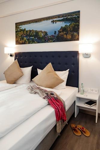 a bedroom with two beds and a painting on the wall at Seehotel am Tankumsee in Isenbüttel