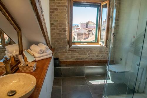 a bathroom with a sink and a shower with a window at Oblivion Luxury Rooms in Split