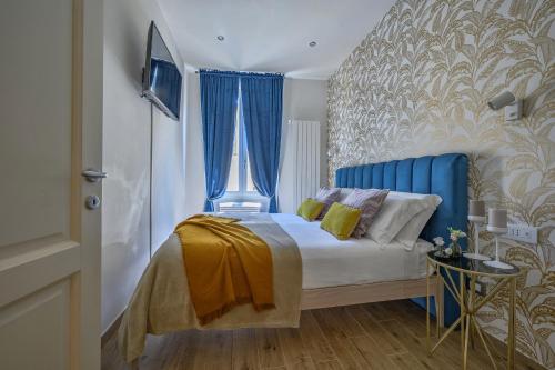 um quarto com uma cama com uma cabeceira azul em Via Macci, 59 - Florence Charming Apartments - Stylish apartments in a vibrant neighborhood with so comfortable beds! em Florença
