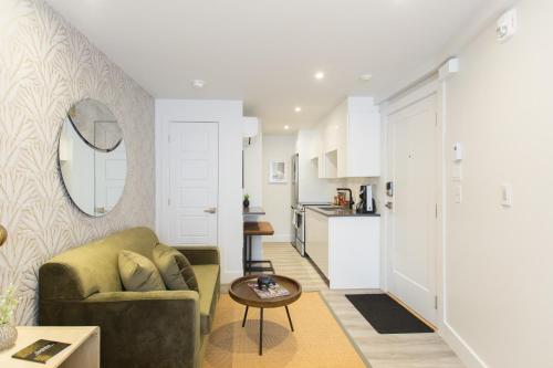 a living room with a couch and a table at Serene and Styled Little Italy Studio full bath by Den Stays in Montréal