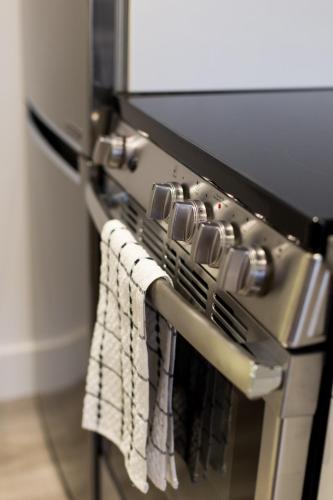a close up of a stove with towels hanging from it at Serene and Styled Little Italy Studio full bath by Den Stays in Montréal