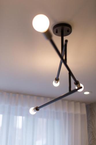 a chandelier hanging from a ceiling with a curtain at Serene and Styled Little Italy Studio full bath by Den Stays in Montréal