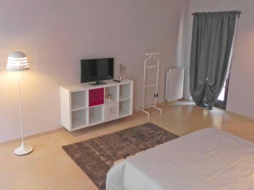 a living room with a tv on a white cabinet at La Casa di Milly in Alba