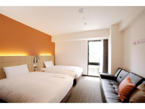 um quarto de hotel com duas camas e um sofá em Hotel Nets Sapporo - Vacation STAY 63535v em Sapporo
