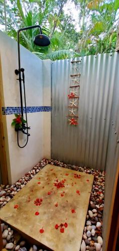 a room with a shower with flowers on the floor at Bak A Yaad in Negril