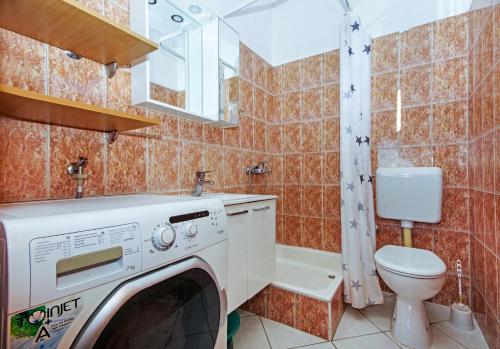 a laundry room with a washer and a toilet at Apartmani ANDRIJA in Živogošće