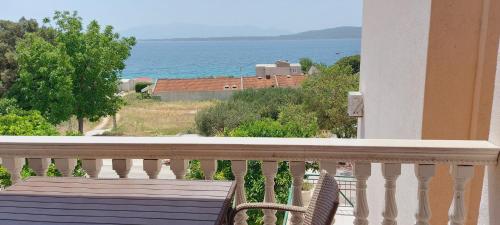a balcony with a bench and a view of the ocean at Apartmani ANDRIJA in Živogošće