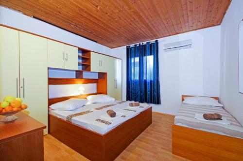 a bedroom with two beds and a bowl of fruit at Apartmani ANDRIJA in Živogošće