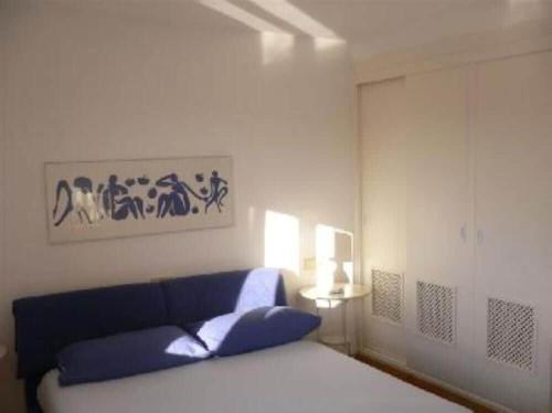 1 dormitorio con 1 cama y 1 sofá azul en Beach view apartment of 87 m2, big terrace, en Cala Murada