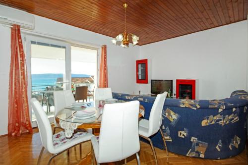 a dining room with a table and a couch at Apartmani ANDRIJA in Živogošće