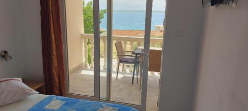 a bedroom with a balcony with a view of the ocean at Apartmani ANDRIJA in Živogošće