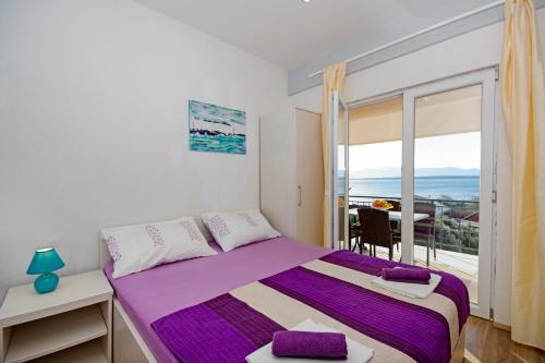 a bedroom with a bed and a large window at Apartmani ANDRIJA in Živogošće