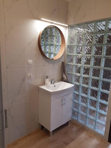 a bathroom with a white sink and a mirror at Apartament Wydminy in Wydminy