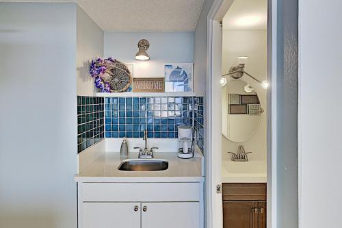 a small kitchen with a sink and blue tiles at Hawaiian Monarch 2108 condo in Honolulu