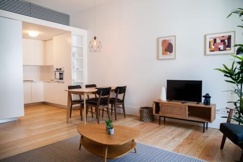 a living room with a dining room table and a television at FLH Praça Comércio Wood Design Flat in Lisbon