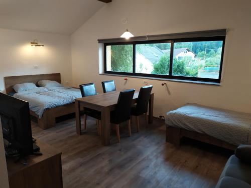 Habitación con mesa de comedor, cama y ventana en Gostilna Ulčar, en Ig