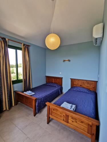 two beds in a room with blue walls at VILLA VAGGELIS in Paphos