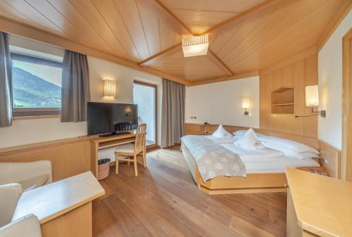 Ένα ή περισσότερα κρεβάτια σε δωμάτιο στο Alpin & Vital Hotel La Perla
