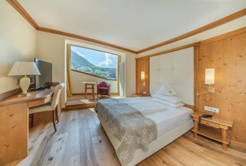 Ένα ή περισσότερα κρεβάτια σε δωμάτιο στο Alpin & Vital Hotel La Perla