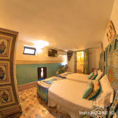 a hotel room with two beds and a mirror at Riad Las Mil y una Noches Tetuan in Tetouan