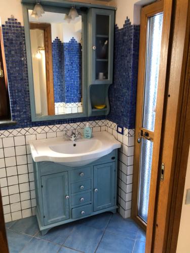y baño con lavabo azul y espejo. en Capri Sun, en Anacapri