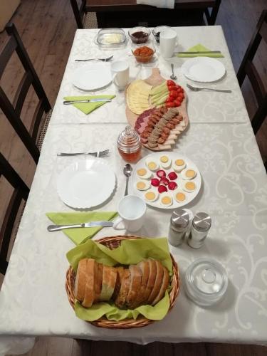 un tavolo bianco con piatti di cibo sopra di Casa de oaspeți Csomortáni vendégház a Şoimeni