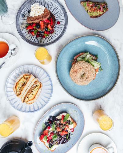 a table with plates of food on it at Kimpton - St Honoré Paris by IHG in Paris