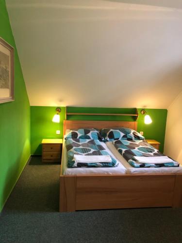 a bedroom with a bed with green walls at Pension Kadlcuv Mlyn in Brno