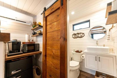 a small bathroom with a toilet and a sink at Deer Creek Tiny Container Home-12 Min to Magnolia in Bellmead