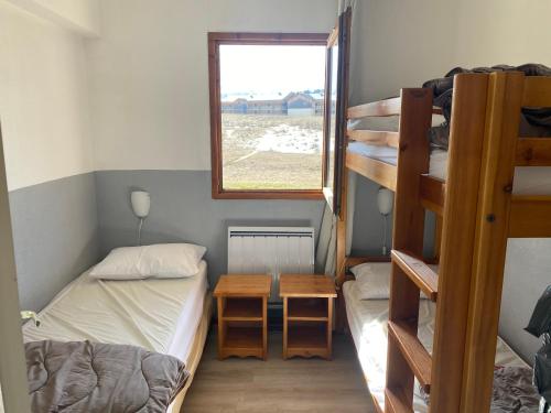 a dorm room with two bunk beds and a window at Les chalets de superD, apt 7-9 personnes in Le Dévoluy