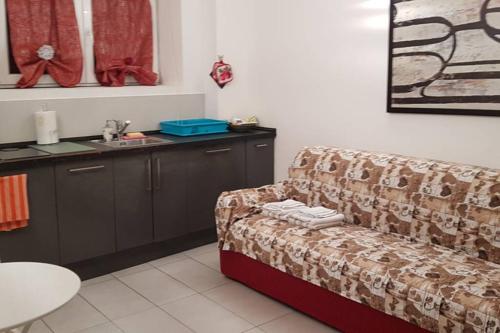 uma sala de estar com um sofá e um lavatório em Affection Apartment em Bolonha