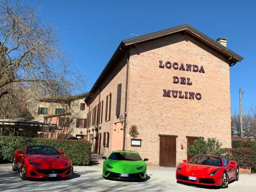 three red and green cars parked in front of a building at Locanda Del Mulino in Maranello