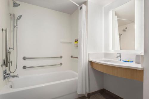 y baño con bañera, lavamanos y ducha. en Holiday Inn Express Dumfries-Quantico, an IHG Hotel en Dumfries
