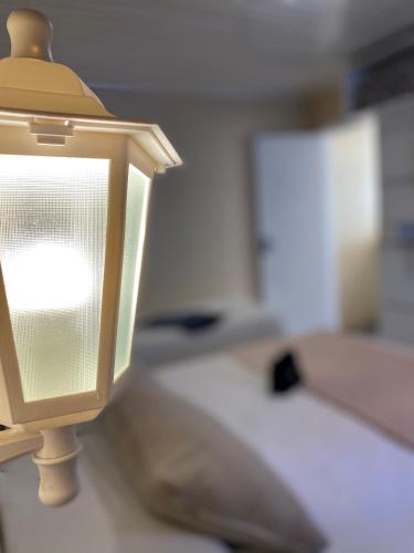 a lamp on a table next to a bed at Pousada Cabanas Rota do Sol in Gramado