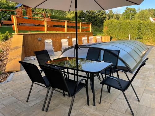 a table and chairs with an umbrella on a patio at Chata Sedloňov in Sedloňov
